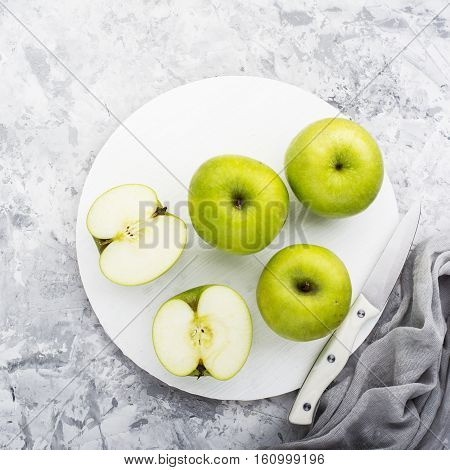 fashionable colors, the greenery apples on a gray marble table on a white cutting board. Top view