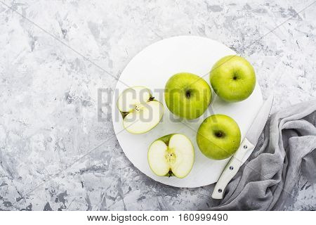 fashionable colors, the greenery apples on a gray marble table on a white cutting board. Top view