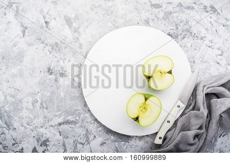 fashionable colors, the greenery apples on a gray marble table on a white cutting board. Top view