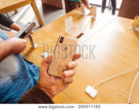 Strasbourg, France - Sep 21, 2018: Apple Store With Curious Male Hand Holding Latest Gold Iphone Xs 