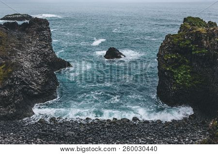 Aerial View Of Beautiful Cliffs In Front Of Blue Ocean In Arnarstapi, Iceland On Cloudy Day