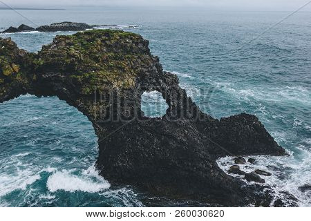 Beautiful Mossy Cliff In Front Of Blue Ocean In Arnarstapi, Iceland