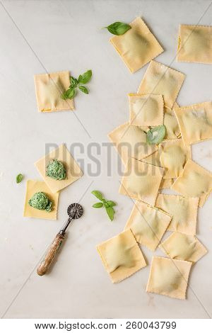 Homemade Raw Uncooked Italian Pasta Ravioli Staffed By Spinach Ricotta, Basil Leavrs, Pasta Cutter. 