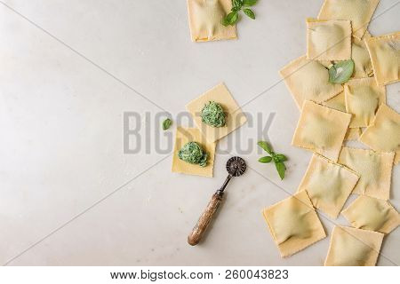 Homemade Raw Uncooked Italian Pasta Ravioli Staffed By Spinach Ricotta, Basil Leavrs, Pasta Cutter. 