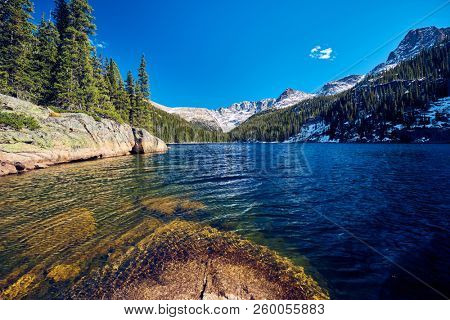 Lake Verna with rocks and mountains around at autumn. Rocky Mountain National Park in Colorado, USA. 