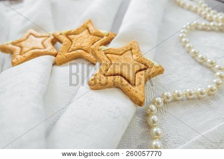 Decorative Golden Stars Handmade From Dough On A White Fabric Surface. Selective Focus.