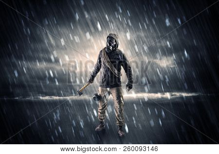 Terrorist in a stormy space with gas mask on his hand and weapons on his arm