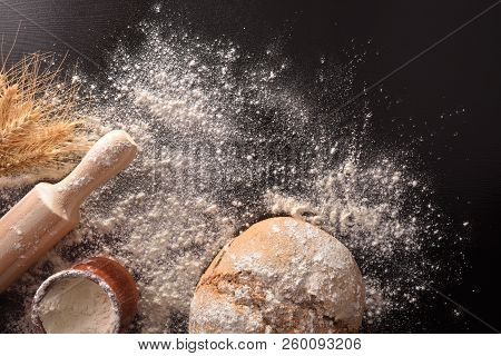Bread Loaf Homemade With Kneader And Flour On Black Table. Top View. Horizontal Composition