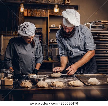 Chef Teaching His Assistant To Bake The Bread In A Bakery.
