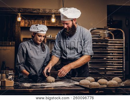 Chef Teaching His Assistant To Bake The Bread In A Bakery.
