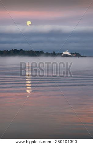 Morning Full Moon. Moonset On The Fraser River In Richmond, British Columbia, Canada.