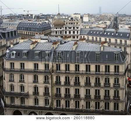 Rooftops Of Paris Showing Haussmann Architecture And Clouds