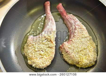 Rack Of Lamb Frying On Pan In Kitchen
