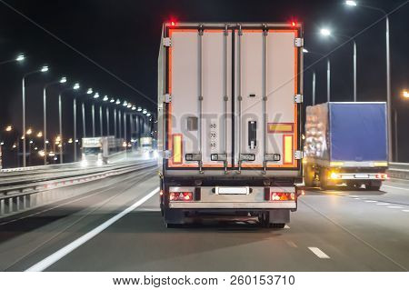 Trucks Move On A Night Illuminated Freeway