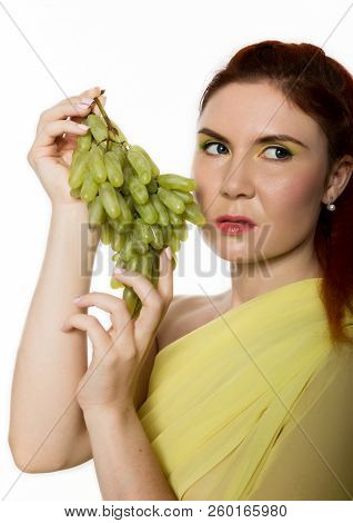 Beautiful Redhead Woman Is Eating Grapes. Concept Of Healthy Eating
