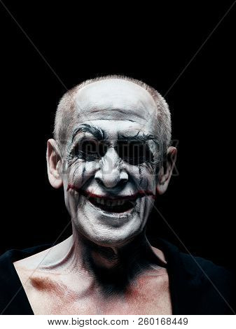 Bloody Halloween Theme: The Crazy Smiling Maniak Face On Dark Studio Background
