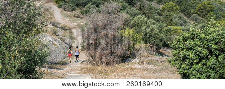 Woman And Teen Running On Ancient Pathway On Philopappos Hill In Central Athens