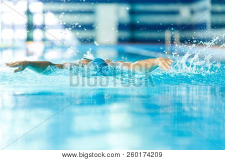 Photo of athlete man sailing down path in pool in training