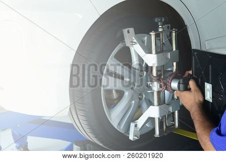 The Mechanic Install A Tool With The Wheel  During  The Step Of Wheel Alignment  At Service Center