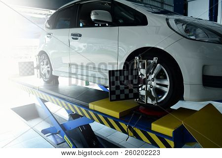 The Mechanic Install The Tool With The Wheel Of The Car That Parked On The Pedestal During The Proce