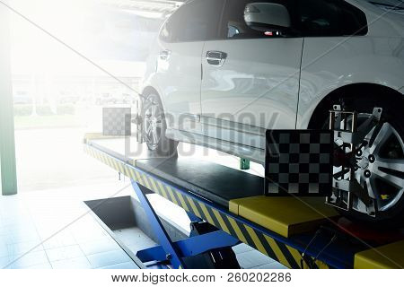 The Mechanic Install The Tool With The Wheel Of The Car That Parked On The Pedestal During The Proce