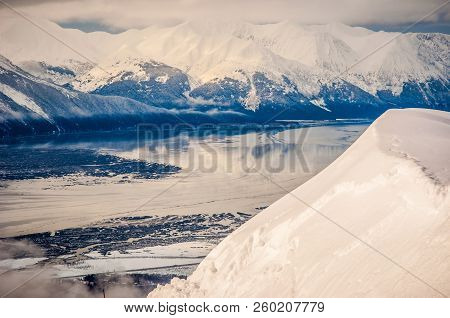 Snow Covered Alaska Winter In The Chugach Mountains Near Alyeska Along The Ice Covered River And Gla
