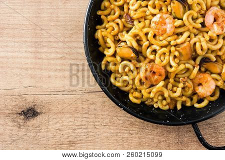 Traditional Spanish Fideua. Noodle Paella On Wooden Table. Top View. Copyspace