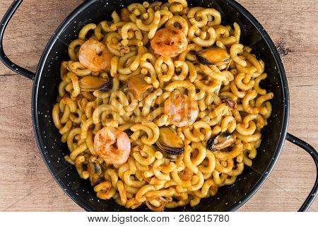 Traditional Spanish Fideua. Noodle Paella On Wooden Table. Top View