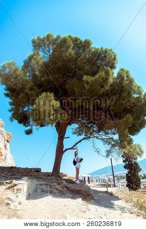 Girl In The Ruins Of An Ancient Acropolis Under A Big Tree