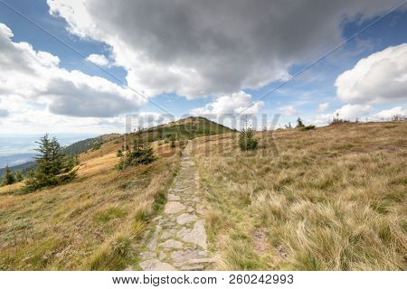 Hiking trail to Mala Babia Gora Mountain from Przelecz Brona Pass in Polish Beskid. High mountains landscape under blue sky with clouds.