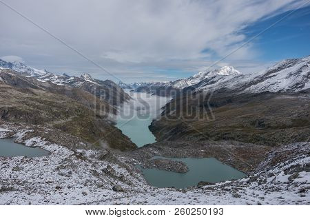 View To Stausee Lake Near Saas Fee In The Southern Swiss Alps From Monte Moro Pass, Italy