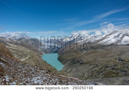 View To Stausee Lake Near Saas Fee In The Southern Swiss Alps From Monte Moro Pass, Italy