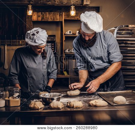 Chef Teaching His Assistant To Bake The Bread In A Bakery.
