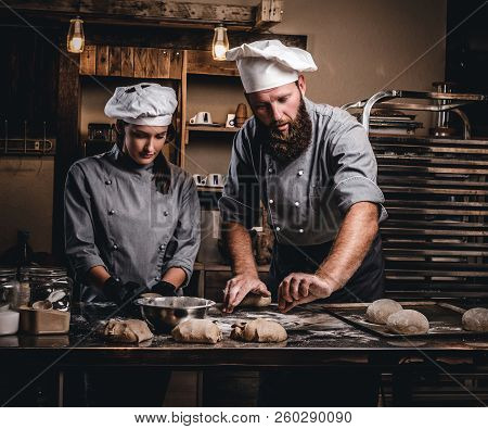 Chef Teaching His Assistant To Bake The Bread In A Bakery.