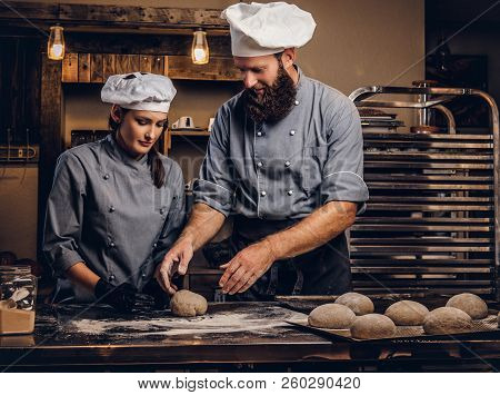 Chef Teaching His Assistant To Bake The Bread In A Bakery.