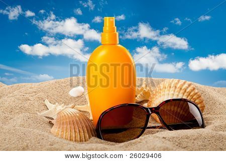 Suntan Oil And Dark Glasses On The Beach