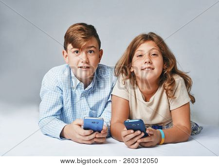 A Very Happy Kids With Smartphones. Stusio Portrait
