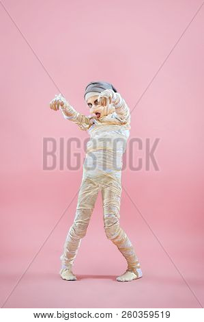 Studio Image Of A Young Teen Girl Bandaged, On Pink Background. Bloody Halloween Theme: The Crazy Ma