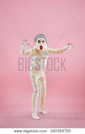 Studio Image Of A Young Teen Girl Bandaged, On Pink Background. Bloody Halloween Theme: The Crazy Ma