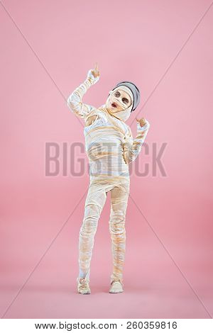 Studio Image Of A Young Teen Girl Bandaged, On Pink Background. Bloody Halloween Theme: The Crazy Ma
