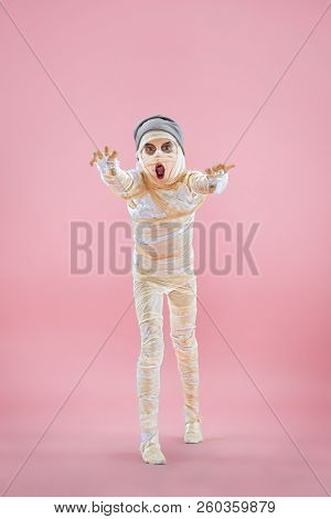 Studio Image Of A Young Teen Girl Bandaged, On Pink Background. Bloody Halloween Theme: The Crazy Ma