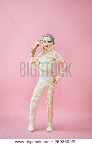 Studio Image Of A Young Teen Girl Bandaged, On Pink Background. Bloody Halloween Theme: The Crazy Ma