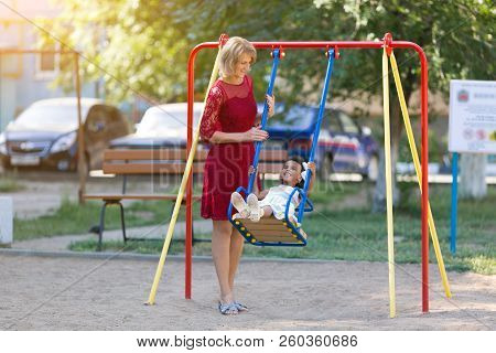 A White Woman Shakes A Black Girl On A Carousel.