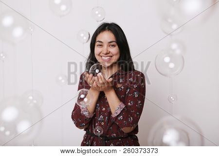 Beautiful Girl Among The Glass Balls One Of Which She Holds In Her Hands