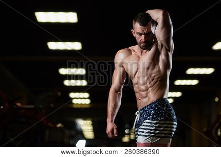 Strong Fitness Man Demonstrates Abdominal Muscles In The Gym. The Concept Of A Healthy Lifestyle