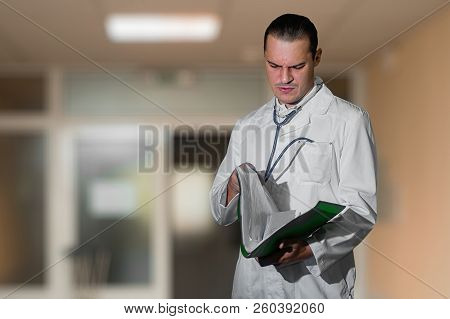 Young Doctor Looking At A Folder In The Hospital