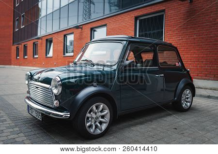 Riga, Latvia - September 2018: Mini Cooper Car Is Staying Parked Near Red Brick Wall.