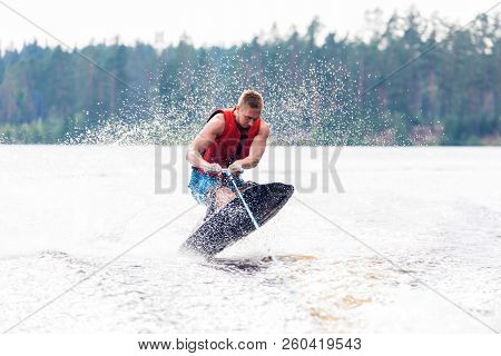 Young Athletic Man Riding Kneeboard On A Lake