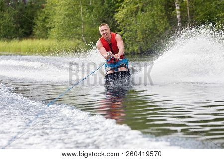 Young Athletic Man Riding Kneeboard On A Lake