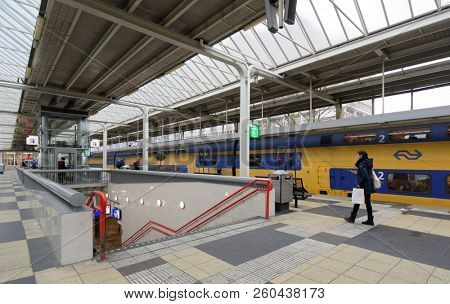 AMSTERDAM, NETHERLANDS - JANUARY 1, 2017: People on the platform of metro and train station. The metro system consists of five routes and serves 58 stations, with a total length of 52.2 km